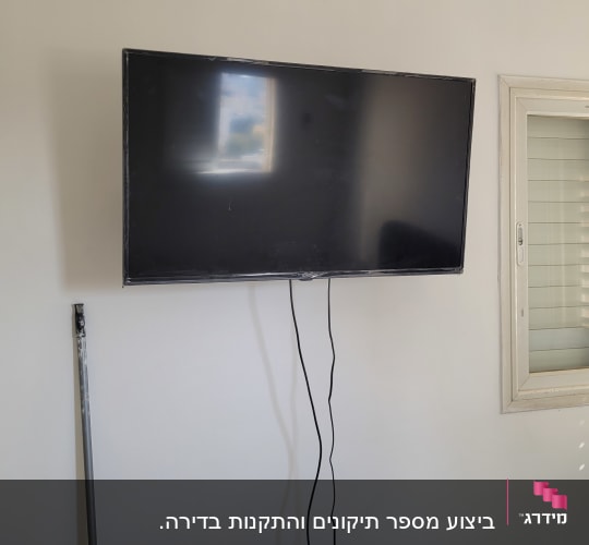 טלוויזיה תלויה על הקיר ליד חלון